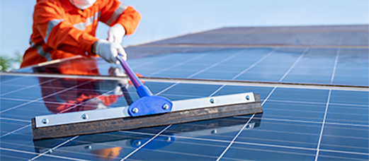 A technician performing solar panel cleaning and debris removal