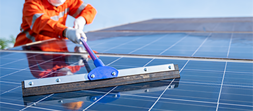 Img_CleaningAndDebrisRemoval A technician performing solar panel cleaning and debris removal