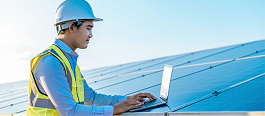 A technician monitors and updates solar panel performance on a computer